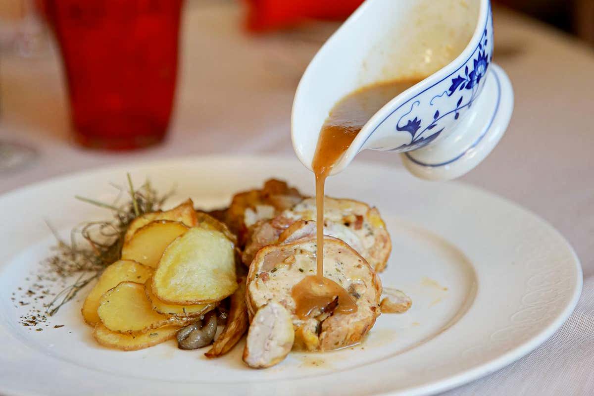 Un piatto caldo e invitante, con carne e contorno di patate, esempio di cucina delle valli