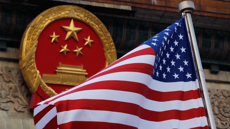 FILE - An American flag is flown next to the Chinese national emblem during a welcome ceremony for visiting U.S. President Donald Trump outside the Great Hall of the People in Beijing on Nov. 9, 2017. (AP Photo/Andy Wong, File)