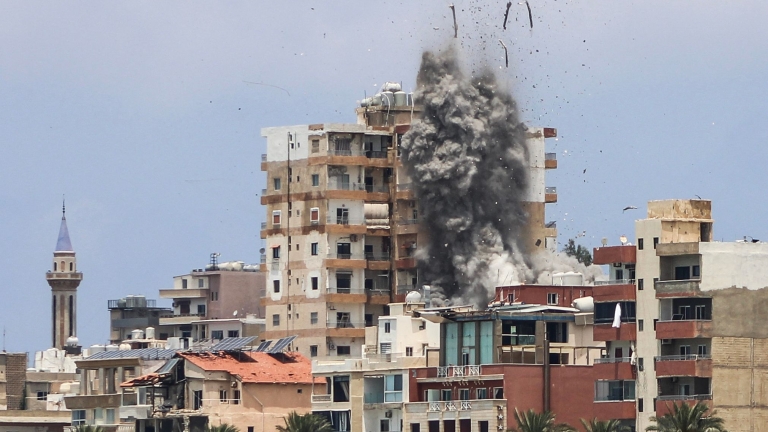 TOPSHOT - Smoke and debris rise following an Israeli airstrike in Tyre on June 9, 2026. Residents of south Lebanon's Tyre including the Christian quarter fled on June 9, an AFP correspondent said, after Israel's army for the first time warned the ...