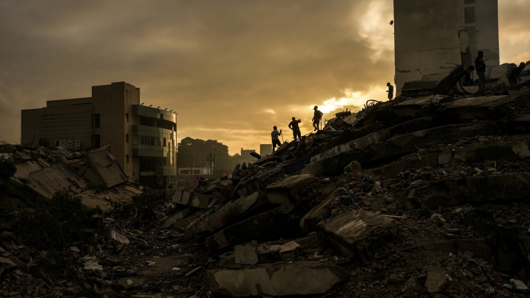 Men searching for survivors stand atop a mountain of rubble three days after twin earthquakes struck, in La Guaira, Venezuela, Saturday, June 27, 2026. (AP Photo/Matias Delacroix)