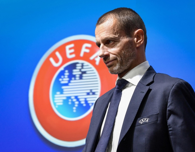 UEFA president Aleksander Ceferin walks past a sign with the UEFA logo after attending a press conference following a meeting of the executive committee at the UEFA headquarters, in Nyon, Switzerland on December 4, 2019. (Photo by Fabrice COFFRINI / AFP)
